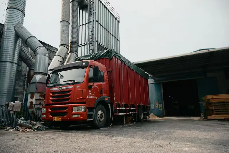 Curtain-sided truck backed up to the loading bay for a container load