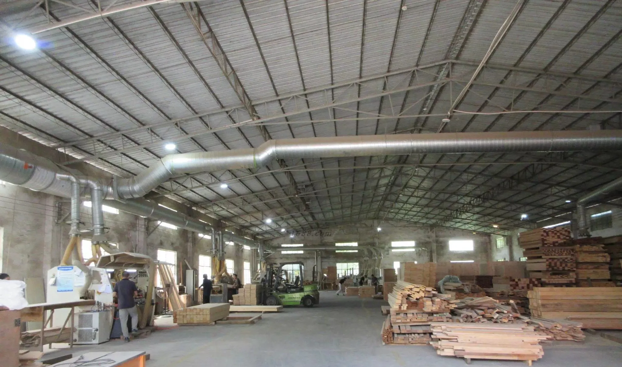 FENYA workshop hall with extraction ducting, machinery, a forklift and stacked sauna timber